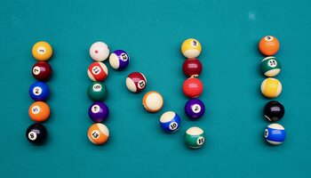Pool balls laid out to spell INI